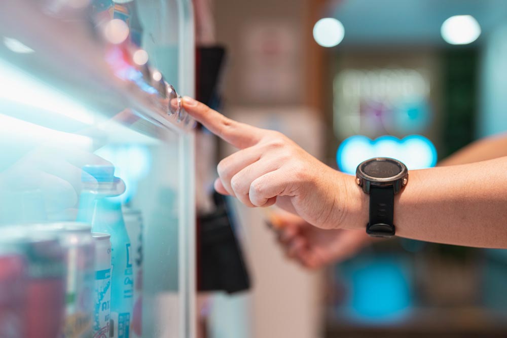 Hand som klickar på en varuautomat
